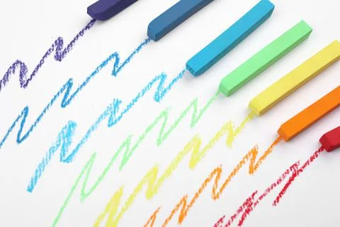 Colorful pastel chalks and scribbles on white background, above view. Drawing Stock Photos