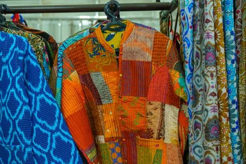 A colorful patchwork jacket hangs on a rack Stock-Fotos