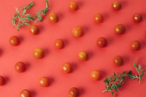 Colorful pattern of cherry tomatoes on red background. Top view Stock Photos