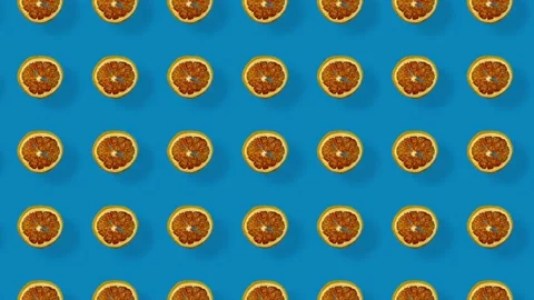 Colorful pattern of dried grapefruit slices on blue background with shadows Stock Footage 167479643