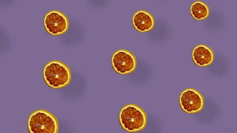 Colorful pattern of dried grapefruit slices on purple background with shadows Stock Footage 167487019