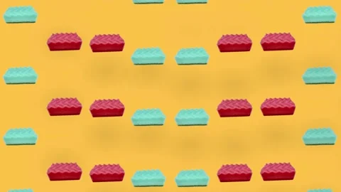 Colorful pattern of green and pink kitchen sponges on orange background Stock Footage 167475927