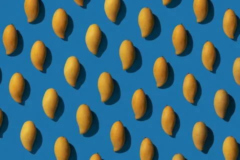 Colorful pattern of yellow mango on bright blue background. Top view. Minimal Stock Photos