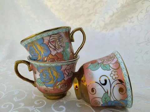 Colorful patterned ceramic cups stacked and resting on a table Stock Photos