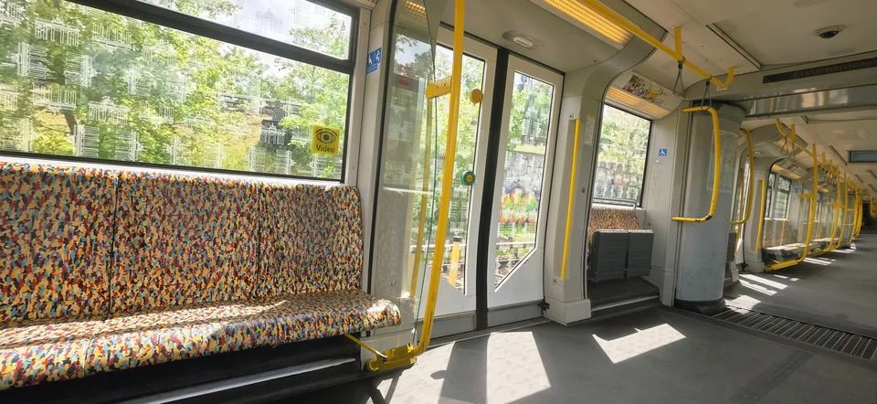Colorful patterned seats in empty subway train with bright natural light Stock Photos