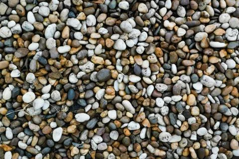 Colorful pebble rounded rock pattern on the beach. Stock Photos