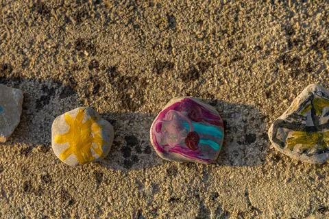 Colorful pebbles painted into patterns by children Stock Photos