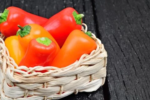 Colorful pepper in a wicker on table Stock Photos