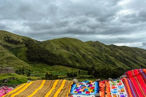 Colorful Peruvian carpets decorating a green Andes mountains vis Stock Photos