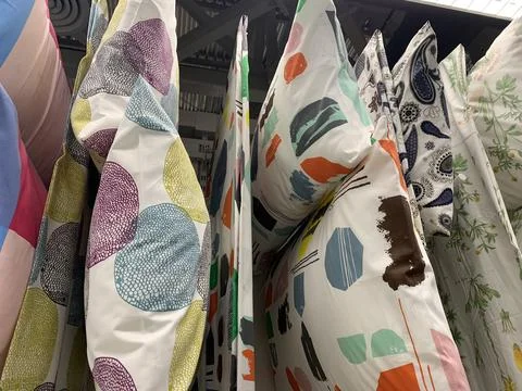 Colorful pillows with different patterns hung from a ceiling wadrobe Stock-Fotos