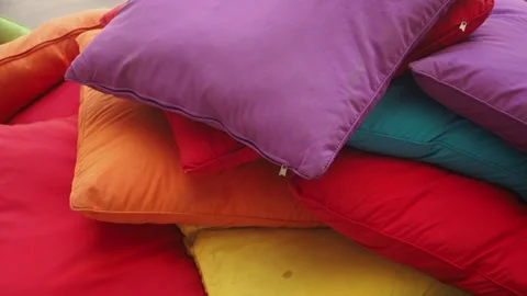 Colorful pillows piled up in a messy stack on outdoor seating area dynamic .. Vídeo Stock 333259179