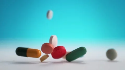 Colorful Pills and Tablets Falling on a White Clean Table. Stock Footage 271006573