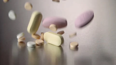 Colorful pills falling and bouncing in slow motion Stock Footage 55339947