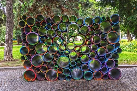 Colorful pipe art installation in public park. Modern outdoor sculpture made of Stock Photos