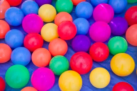 Colorful plastic balls on blue background. Stock Photos