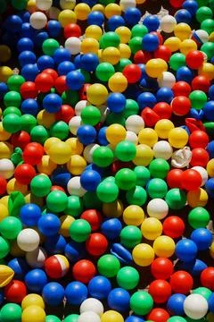 Colorful plastic balls scattered on the ground during a fun playtime Stock Photos