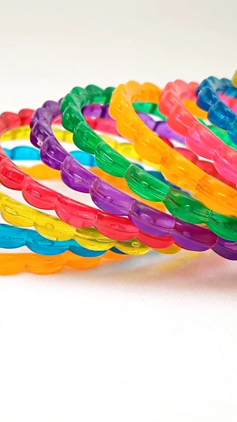 Colorful plastic bangles arranged moving on white background, accessory Stock Footage 320669459