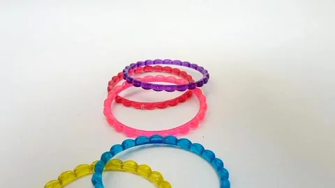 Colorful plastic bangles dropping on white background, fashion accessory Stock Footage 320669136