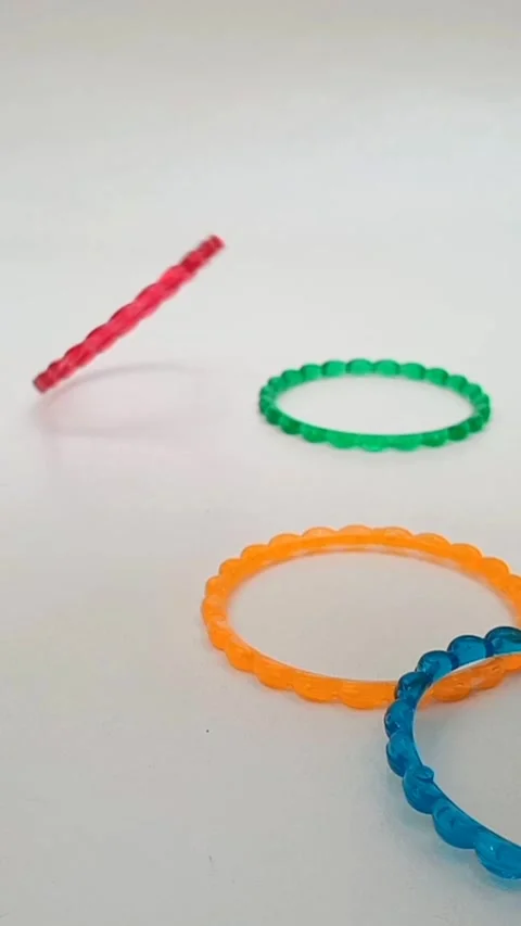 Colorful plastic bangles falling on white background, fashion accessory Stock Footage 320669143