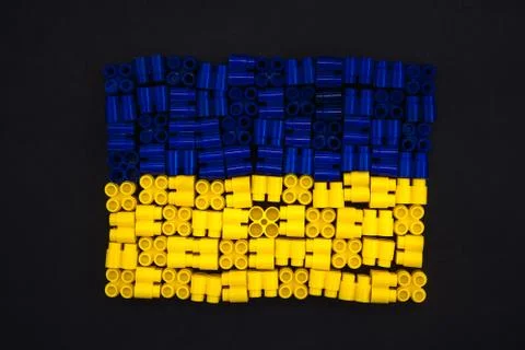 Colorful plastic bricks which form the Ukraine flag on black paper background Stock Photos