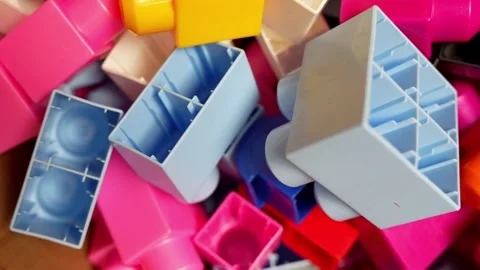 Colorful plastic building blocks piled in a messy toy bin, close-up on Stock Footage 325753384