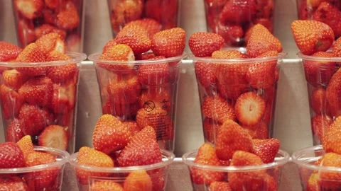 Colorful plastic cups filled with fresh strawberries available for sale at a Stock Footage 280584636