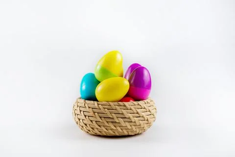Colorful Plastic Easter Eggs in a wicker basket on white background Stock-Fotos
