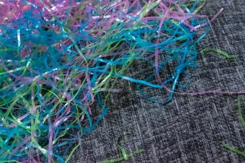 Colorful plastic easter grass laying on black and white material decorating for Stock Photos