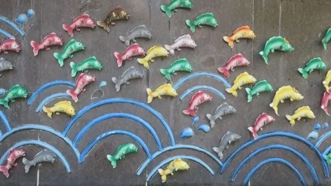 Colorful plastic fish on the wall Stock Footage 70303046