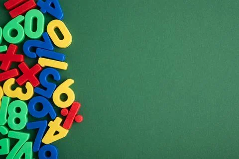 Colorful plastic numbers and math symbols on green background Stock Photos
