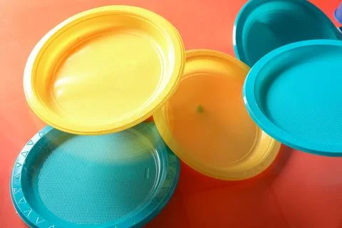 Colorful plastic plates levitating on red background Stock Photos