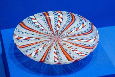 Colorful plate with red pattern on blue table close-up Stock Photos