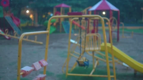 Colorful playground equipment stands empty during the early evening in a quiet Stock Footage 341756335