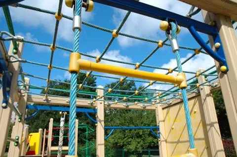 Colorful playground nearby trees Stock Photos