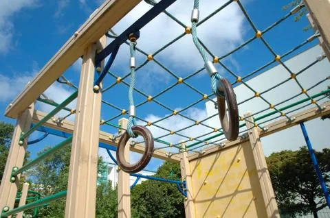 Colorful playground nearby trees Stock Photos