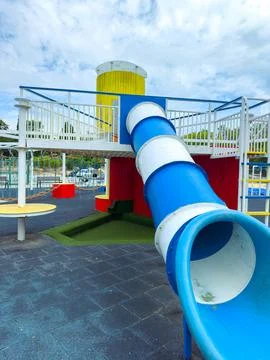 Colorful playground structure with a slide during the day in an urban park .. Stock Photos