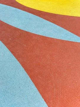 Colorful playground surface with curved patterns on a sunny day Stock Photos