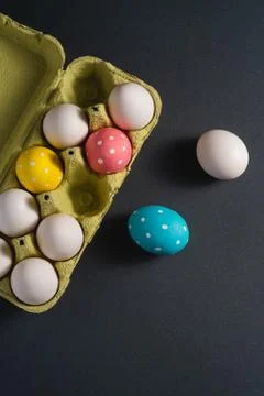 Colorful polka dot Easter eggs in egg tray on dark grey black plain background Stock Photos