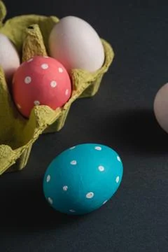 Colorful polka dot Easter eggs in egg tray on dark background, greeting card Stock Photos