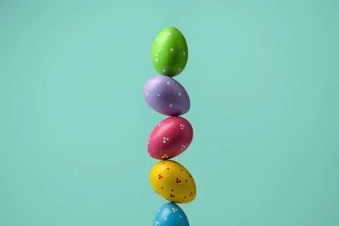 Colorful polka dot Easter eggs rise in tall stack on mint turquoise backgroun 写真素材