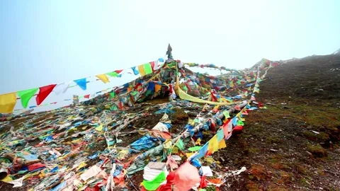Colorful prayer flags adorn a mountain peak in a buddhist tradition Stock Footage 312303953