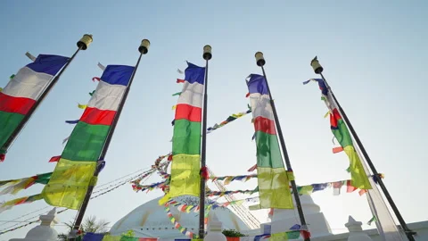 Colorful prayer flags on flagpoles flutter at white festive Swayambhunath stupa Stock Footage 167490602