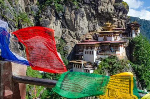 Colorful prayer flags flapping in the crazy wind before sacred Buddhist monas Stock Photos