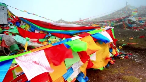 Colorful prayer flags flutter on a mountain in a spiritual landscape Stock Footage 312304505