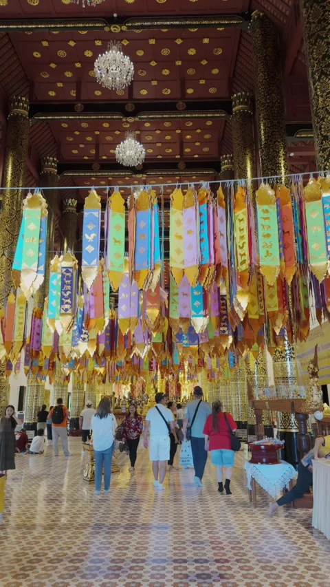 Colorful prayer flags hang inside Wat Phra Singh, Chiang Mai, Thailand Stock Footage 336581131