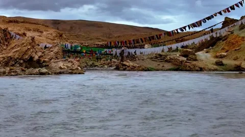 Colorful Prayer Flags Over Flowing River in Arid Mountain Landscape Tibet China Stock Footage 346585352
