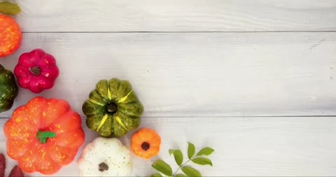 Colorful pumpkins, fall leaves and place for text on an white wooden background Stock Footage 345703706