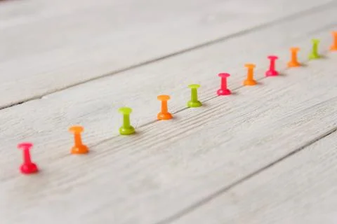 Colorful Pushpins Arrayed in Row Upscale on White Wooden Background, Copy Space 写真素材