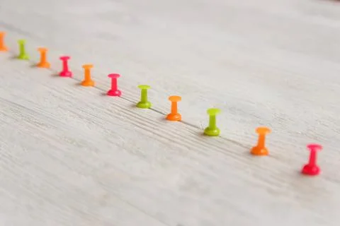 Colorful Pushpins Arrayed in Row on White Wooden Background, Copy Space Stock Photos