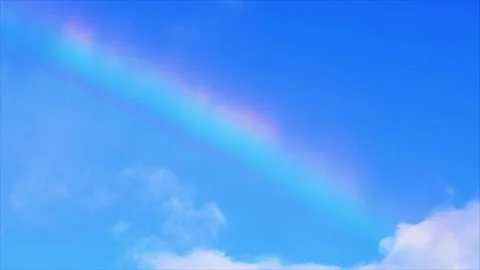 Colorful Rainbow Arching Across Bright Blue Sky in Clear Weather Video stock 343513655